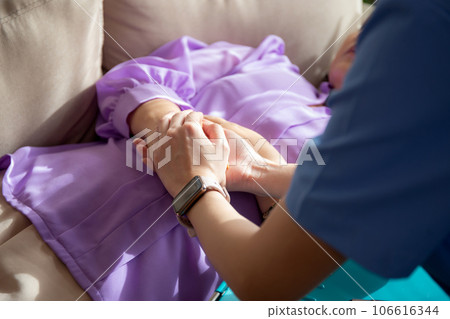 Closeup hands caregiver woman or doctor encourage and care senior while lying on sofa. 106616344
