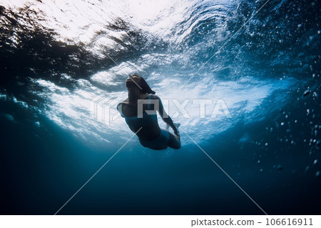 Woman underwater with ocean wave and sun light. Vacations in ocean Woman underwater with ocean wave and sun light. Vacations in ocean 106616911