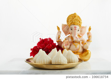 Idol of lord Ganesha with Modak Sweet Dish and flower. Ganesh chaturthi Idol of lord Ganesha with Modak Sweet Dish and flower. Ganesh chaturthi 106618734