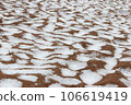 Snow on a sandy beach, undulating sand, summer. Disturbance of the earth's climate, ecological disaster 106619419