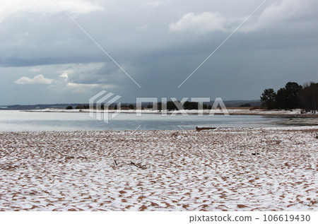Snow on a sandy beach, undulating sand, summer. Disturbance of the earth's climate, ecological disaster 106619430