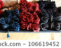 Skeins of 6mm diameter jute rope for Japanese bondage and shibari. Blue, red, black and undyed ropes at the bdsm fair at the shibari festival. Skein of professional knitting. 106619452