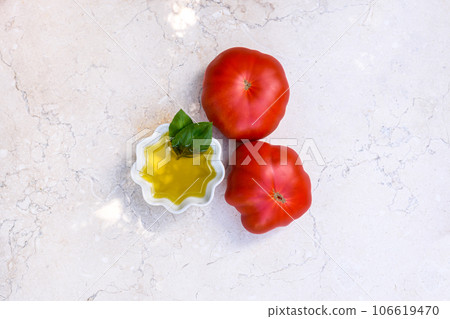 Olive oil and tomatoes on limestone table. Olive oil and tomatoes on limestone table. 106619470