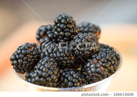 Fresh sweet blackberry in glass on a wooden table, rustic background, selective focus Fresh sweet blackberry in glass on a wooden table, rustic background, selective focus 106619806
