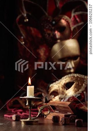 Burning candle, dice, and carnival masks. Burning candle, dice, and carnival masks. 106620237