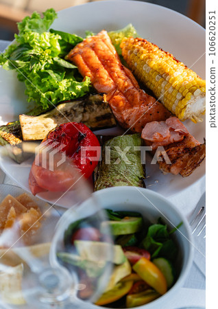 Grilled vegetables on a white dish. Grilled red fish with vegetables. Grilled vegetables on a white dish. Grilled red fish with vegetables. 106620251