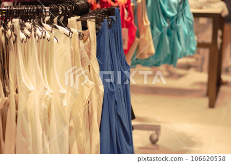 Female clothes on hangers. Clothes in retail shop. Sales season in fashion industry. New collection clothes. Showroom interior. Boutique in shopping mall. Buying and selling. Clothes and price tags. Female clothes on hangers. Clothes in retail shop. Sales season in fashion industry. New collection clothes. Showroom interior. Boutique in shopping mall. Buying and selling. Clothes and price tags. 106620558