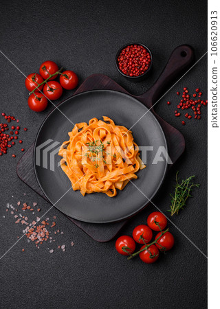 Delicious fresh pasta with pesto sauce, salt, spices and herbs on a ceramic plate Delicious fresh pasta with pesto sauce, salt, spices and herbs on a ceramic plate 106620913