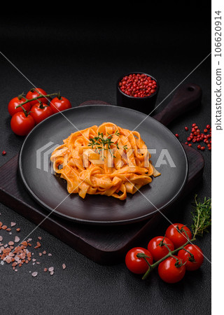Delicious fresh pasta with pesto sauce, salt, spices and herbs on a ceramic plate 106620914