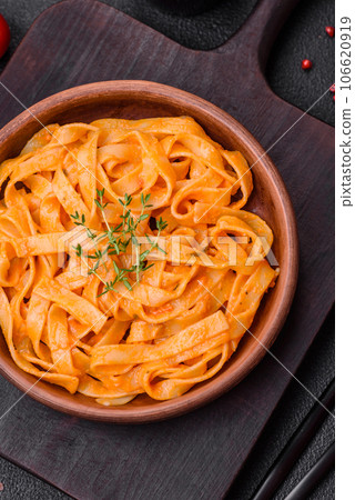 Delicious fresh pasta with pesto sauce, salt, spices and herbs on a ceramic plate Delicious fresh pasta with pesto sauce, salt, spices and herbs on a ceramic plate 106620919