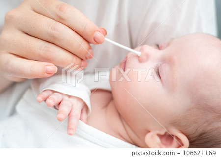 Cotton stick aids in baby nasal care, Concept of trusted traditional methods Cotton stick aids in baby nasal care, Concept of trusted traditional methods 106621169