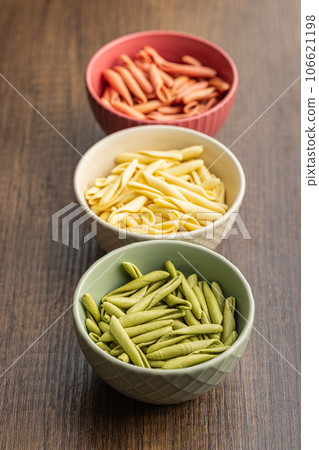 Fusilli pugliesi. Italian tricolor twisted pasta in bowl. 106621198