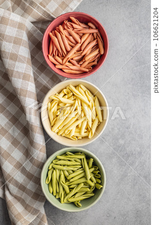 Fusilli pugliesi. Italian tricolor twisted pasta in bowl. Top view. Fusilli pugliesi. Italian tricolor twisted pasta in bowl. Top view. 106621204