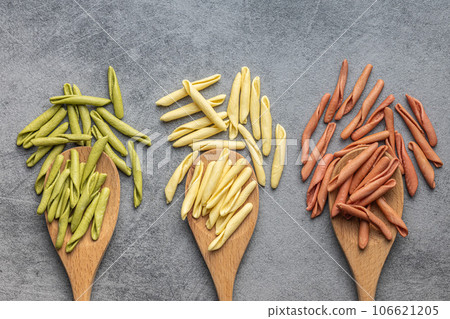 Fusilli pugliesi. Italian tricolor twisted pasta on wooden spoons. Top view. 106621205