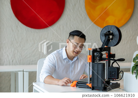 Male designer using 3D printer in office, working with new technology ideas. 106621910