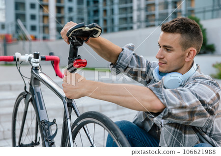 Man in checkered shirt repairing a bike 106621988