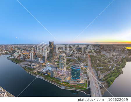 Yekaterinburg city and pond aerial panoramic view at summer or early autumn sunset. Night city in the early autumn or summer. Yekaterinburg city and pond aerial panoramic view at summer or early autumn sunset. Night city in the early autumn or summer. 106622039