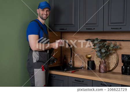 Professional plumber fixing water tap in kitchen Professional plumber fixing water tap in kitchen 106622729