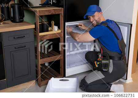 An electrical technician working on the repair of a refrigerator or refrigeration equipment An electrical technician working on the repair of a refrigerator or refrigeration equipment 106622731