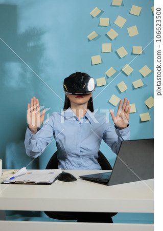 Creative asian woman wearing virtual smart glasses joins a business meeting in the augmented reality metaverse. Office employee concentrating while working with modern technology. Creative asian woman wearing virtual smart glasses joins a business meeting in the augmented reality metaverse. Office employee concentrating while working with modern technology. 106623500