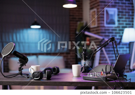 Empty home production studio with professional podcasting tools recording sound for streaming sites entertainment show. Live broadcasting from cozy location in living room decorated with purple lights Empty home production studio with professional podcasting tools recording sound for streaming sites entertainment show. Live broadcasting from cozy location in living room decorated with purple lights 106623501
