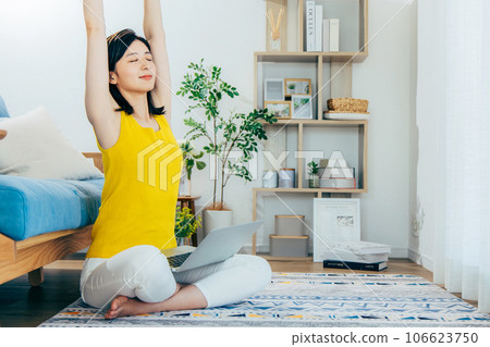 A woman watching a computer in a room A woman watching a computer in a room 106623750