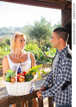 Young man and woman gardeners talking in vegetable garden 106625534