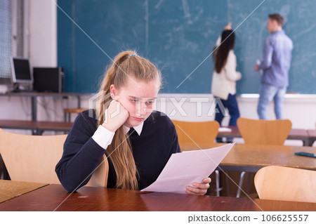 Young sad girl preparing for the exam in classroom Young sad girl preparing for the exam in classroom 106625557