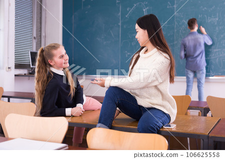 Female students talking and using smartphone during break 106625558