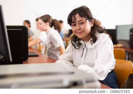 Concentrated Asian female student using PC and studying computer science in the classroom 106625583