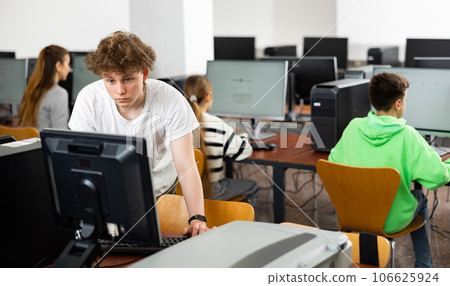 Portrait of guy working at computer in computer class at school Portrait of guy working at computer in computer class at school 106625924