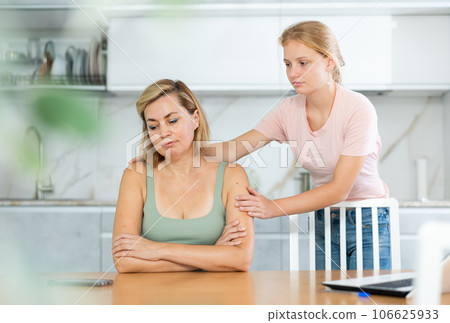 Teenage daughter cheers and encourages mother, upset by sudden bad news. 106625933