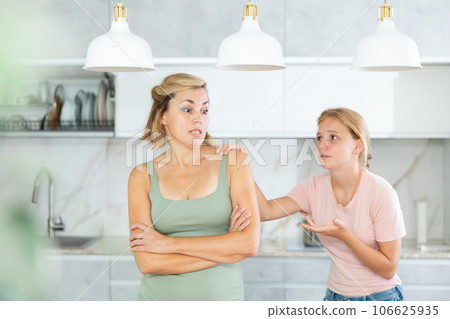 Agitated daughter imploringly asks angry mother for forgiveness. Agitated daughter imploringly asks angry mother for forgiveness. 106625935