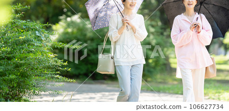 撐著陽傘行走的中年婦女 106627734