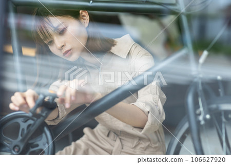 A female staff member repairing a bicycle 106627920