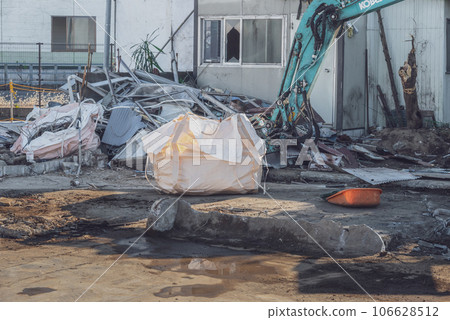 Heavy machinery processing scrap metal from a demolished prefabricated office building Heavy machinery processing scrap metal from a demolished prefabricated office building 106628512