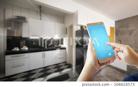 Female hand is adjusting lighting with smart phone 106628573