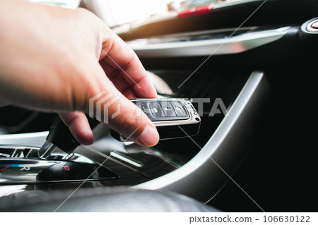 Close up of a driver hand holding a car keyless remote in a car. Close up of a driver hand holding a car keyless remote in a car. 106630122