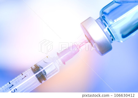 doctor's hand holds a syringe and a blue vaccine bottle at the hospital. Health and medical concepts. doctor's hand holds a syringe and a blue vaccine bottle at the hospital. Health and medical concepts. 106630412