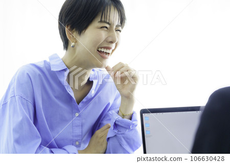 年輕女子在辦公桌前微笑和交談 106630428
