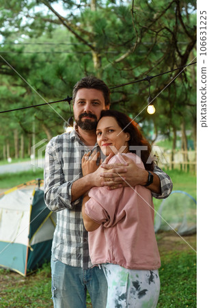 Young married couple emracing and standing in the forest in the evening Young married couple emracing and standing in the forest in the evening 106631225