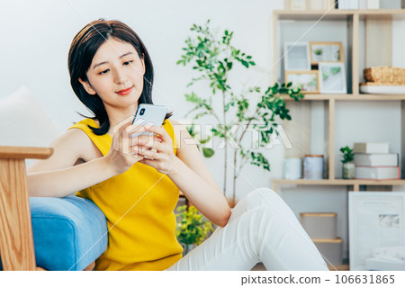 看智能手機的婦女在屋子裡 106631865