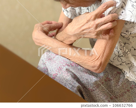 An elderly woman crosses her arms in confusion in front of her desk 106632766