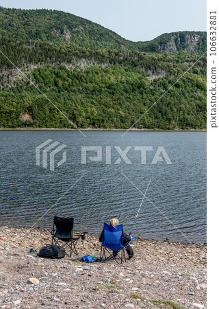 Girl fishing at lake near the Cape Breton Island Coast line cliff scenic Cabot Trail route, Nova Scotia Hghlands Canada Girl fishing at lake near the Cape Breton Island Coast line cliff scenic Cabot Trail route, Nova Scotia Hghlands Canada 106632881