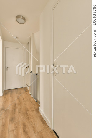 an empty room with white walls and wood flooring the door is open to let in light into the room an empty room with white walls and wood flooring the door is open to let in light into the room 106633780