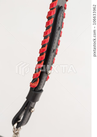 Black leather bag strap with red decoration, close-up on white background Black leather bag strap with red decoration, close-up on white background 106633962