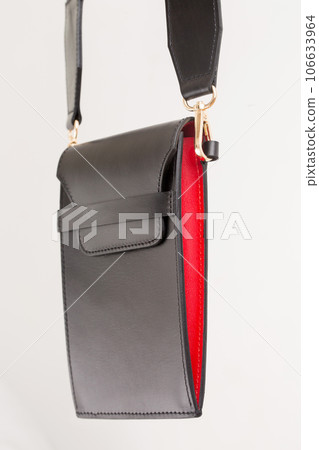 A small smartphone bag made of black leather with red inserts on the strap A small smartphone bag made of black leather with red inserts on the strap 106633964