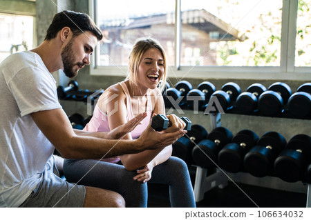 Man and woman working out with dumbbell in fitnes sport gym 106634032