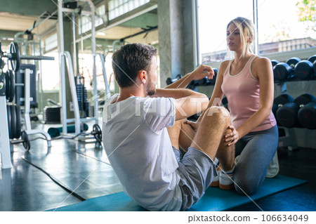 Sport man sit uplying on yoga mat exercise in gym Sport man sit uplying on yoga mat exercise in gym 106634049