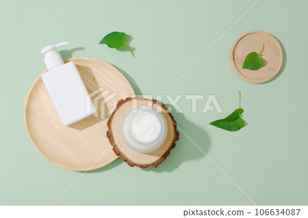 Scene for advertising cosmetic with mockup bottles and fish mint leaves on green background. Fish mint is a natural medicine with anti-inflammatory and antibacterial ingredients and rich in vitamin A 106634087